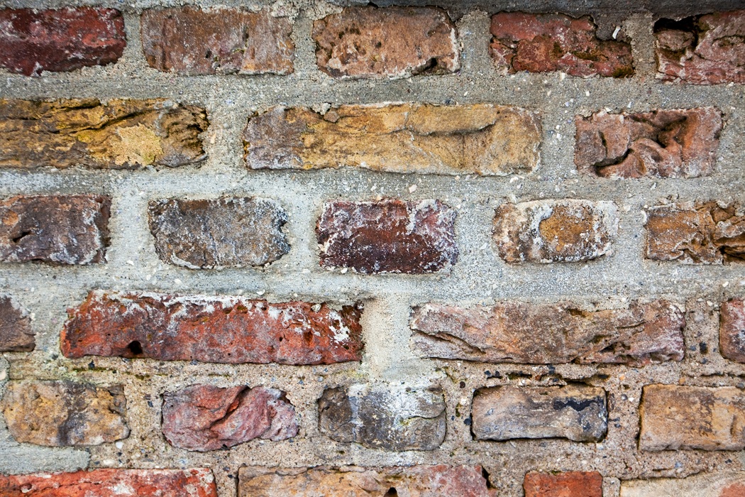 Experienced masons repairing a brick wall in New Jersey using proper techniques for optimal curing and durability. - Masonry Work in NJ